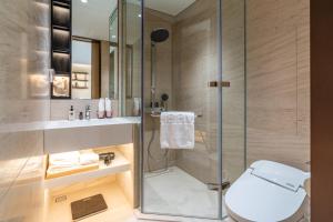 a bathroom with a shower and a toilet and a sink at The Five Hotel & Resort Evara - 24 Hours stay in Dong Anh +31 photos