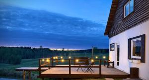 a deck with a table and chairs next to a building at Forest Lodge & Spa in Gauja National Park - Kaķukalns in Straupe