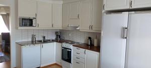 a kitchen with white cabinets and white appliances at Apartment Kamreerintie in Laihia +49 photos