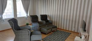 a living room with three chairs and a television at Apartment Kamreerintie in Laihia