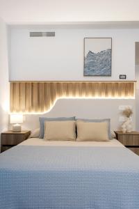 a bedroom with a large bed with a blue bedspread at REM III Premium Torrevieja in Torrevieja