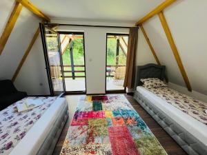 a room with two beds and a rug on the floor at Mountain Holiday Homes in Kostel