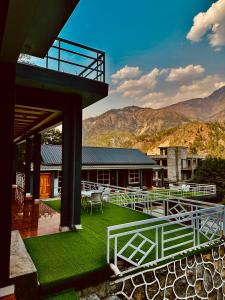 a house with a green yard with a white fence at Valledor Resort in Bālākot