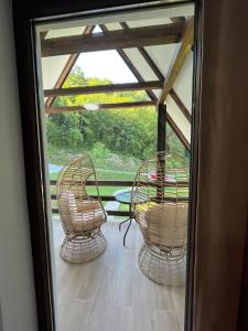 a screened in porch with two chairs and a table at Mountain Holiday Homes in Kostel