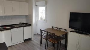 a kitchen with a table and chairs and a television at Sokoburu Deluxe Beach in Hendaye