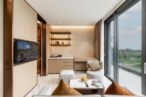 a living room with a couch and a table at The Five Hotel & Resort Evara - 24 Hours stay in Dong Anh