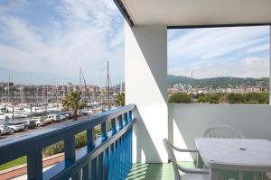 a balcony with a table and chairs and a view of a harbor at Sokoburu Deluxe Beach in Hendaye
