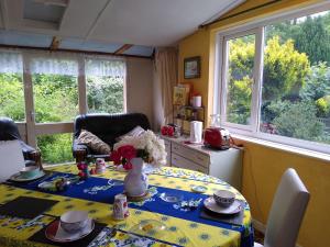 a dining room with a table with a table cloth at Enstone Homestay in Sidmouth