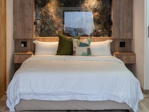 a bedroom with a large white bed with pillows at Lombard Manor in Pretoria