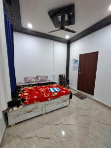 a bedroom with a bed with red flowers on it at Shivansh Homestay in Mathura