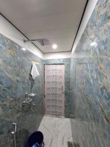 a bathroom with a shower with a stone wall at Shivansh Homestay in Mathura +11 photos