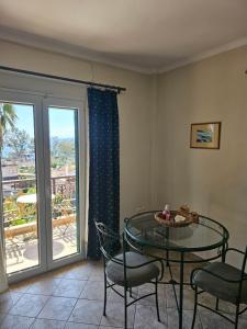 a dining room with a table and chairs and a balcony at Amfitrion Apartments in Gythio