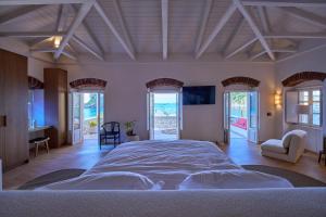 a large bedroom with a large bed and windows at Casa Zacco in Parga