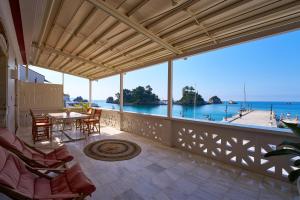 a balcony with a table and chairs and a view of the ocean at Casa Zacco in Parga