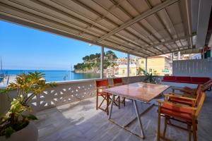 a table and chairs on a balcony with a view of the ocean at Casa Zacco in Parga +20 photos