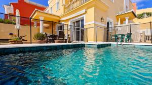 a swimming pool in front of a building at Viña-Home in Torre del Mar