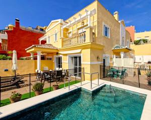a villa with a swimming pool in front of a house at Viña-Home in Torre del Mar