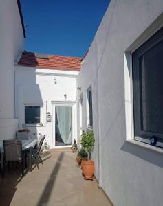 a balcony of a white house with a table and chairs at Cosy 21 in Ialysos