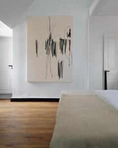 a white room with a bed and a painting on the wall at Hakanto House in Antananarivo