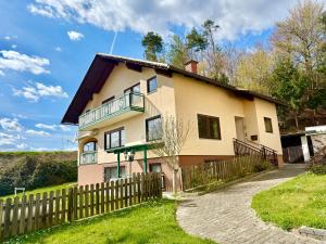 a house with a fence in front of it at Apartment Karawankenblick with Lake View - Free Parking in Pörtschach am Wörthersee