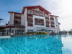 a hotel with a swimming pool in front of a building at Sokoburu Deluxe Beach in Hendaye