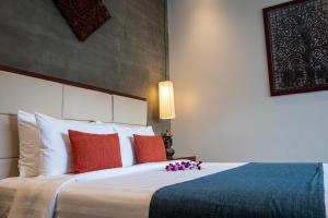 a bedroom with a large bed with red and blue pillows at Grange Boutique Siem Reap in Siem Reap