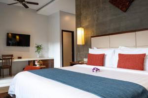 a bedroom with a large white bed with red pillows at Grange Boutique Siem Reap in Siem Reap