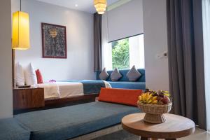 a living room with a bed and a couch and a table at Grange Boutique Siem Reap in Siem Reap