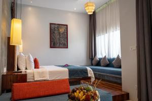 a hotel room with a bed and a couch at Grange Boutique Siem Reap in Siem Reap +163 photos