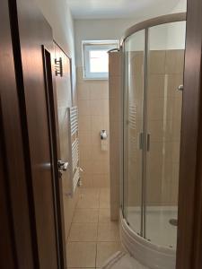 a bathroom with a shower and a glass door at Sentio Inn 2 in Dunajská Streda +10 photos