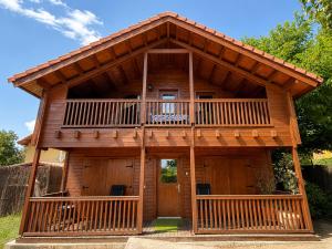 a log cabin with a balcony and a deck at Casa rural 'La Huerta' in Rascafría