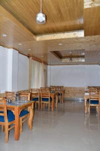 a dining room with wooden tables and chairs at The sky walk in Manāli