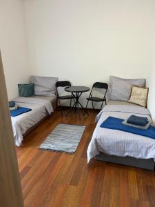 two beds in a room with a table and chairs at Sentio Inn 2 in Dunajská Streda