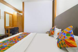 a bedroom with a bed and two pillows at FabHotel Nand's Residency in Patna