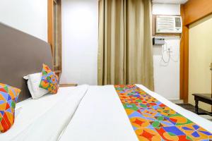 a hotel room with a bed with a colorful blanket at FabHotel Nand's Residency in Patna