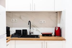 a kitchen with a sink and a red appliance at Syntagma Luxury Suites 1 in Athens +3 photos