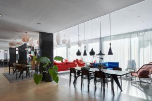 a living room with a table and a red couch at citizenM Amsterdam South in Amsterdam +16 photos