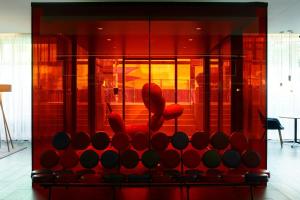 a red cabinet with a red chair in a room at citizenM Amsterdam South in Amsterdam