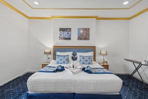 a bedroom with a large bed with blue pillows at Sama Al Deafah Hotel in Mecca