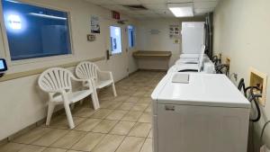 a waiting room with white chairs and a refrigerator at Motel 6-Brownsville, TX in Brownsville