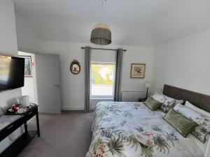 a bedroom with a bed and a flat screen tv at Lavally House in Gort +31 photos