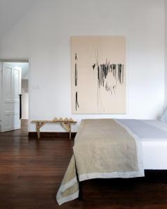 a bedroom with a bed and a painting on the wall at Hakanto House in Antananarivo