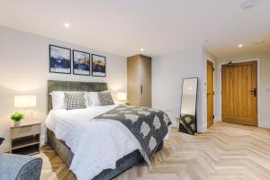 a bedroom with a large bed and a chair at Rock Mill - Deluxe Studio Apartment with Balcony in Stony Middleton