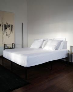 a large bed with white sheets and pillows on it at Hakanto House in Antananarivo