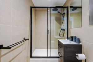 a bathroom with a glass shower with a sink at Rock Mill - Deluxe Studio Apartment with Balcony in Stony Middleton