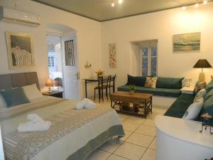a bedroom with a bed and a living room at Perakis Apartments in Hydra