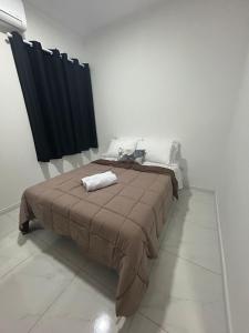 a bedroom with a bed with a brown blanket at Beautiful Cozy Beach House Accommodation in Guaratuba +26 photos