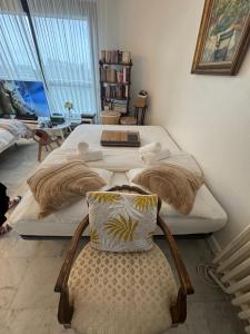 a bedroom with two beds and a chair in it at Lilas house in Les Lilas