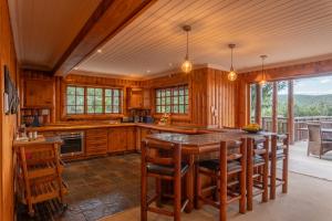 a kitchen with wooden cabinets and a table with chairs at Addo Nyala Guest Lodge in Paterson