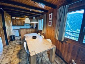 a wooden table in a kitchen with a large window at Chalet Le Jeuna in Morgins